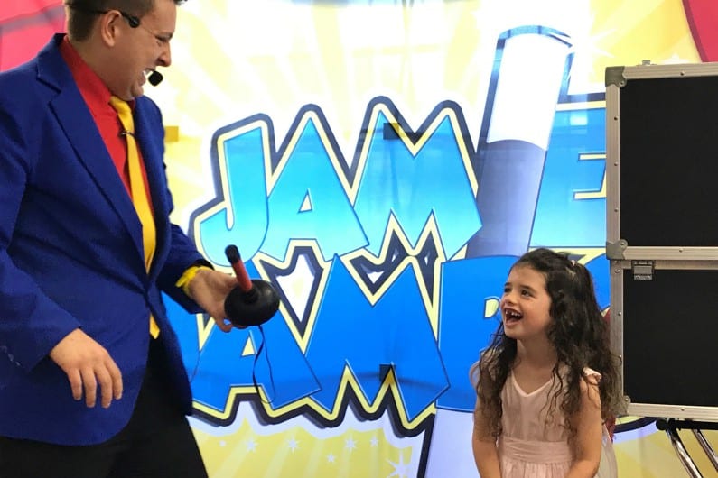 Children's entertainer performing magic for a delighted girl